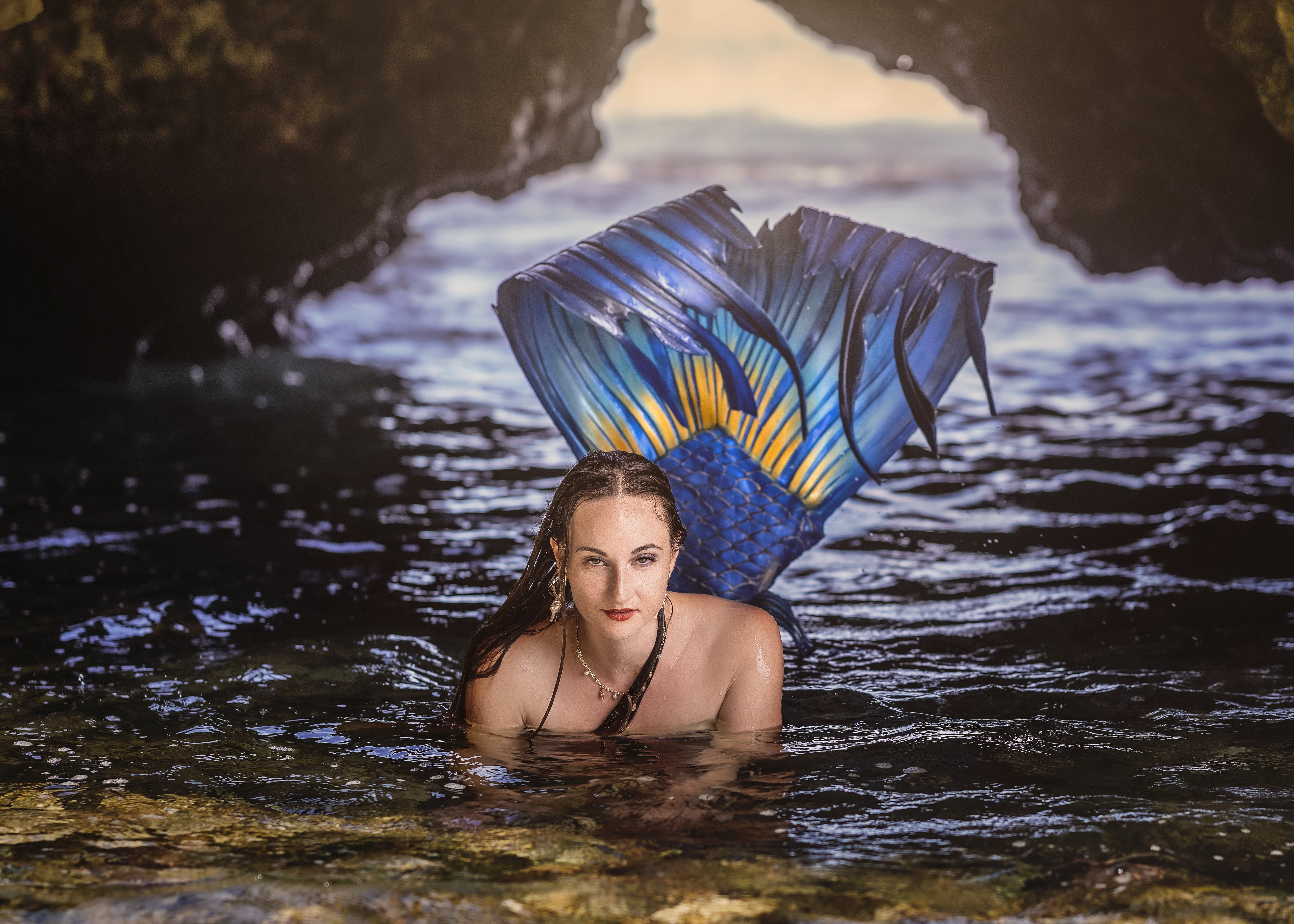 Mermaid under rock arch