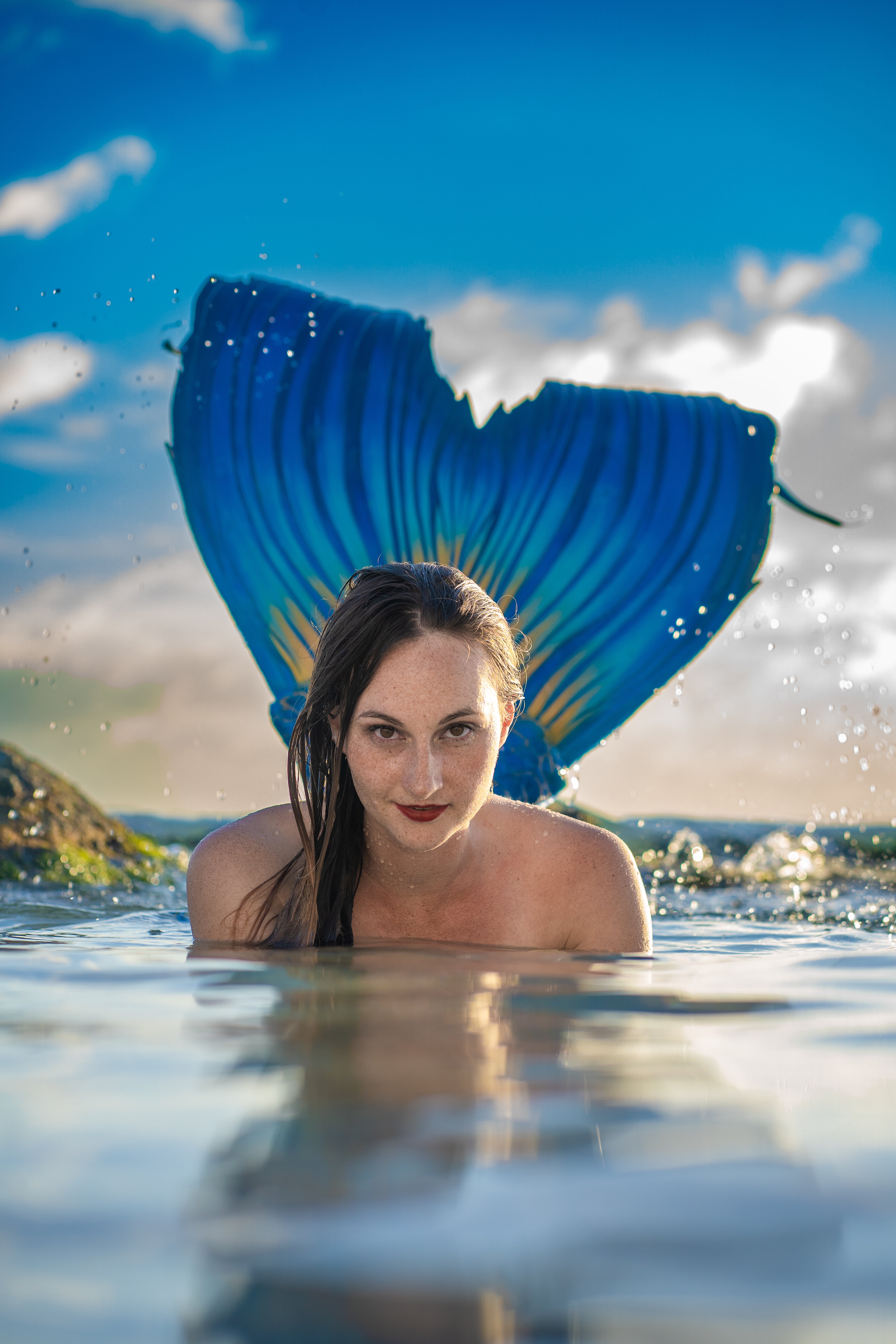 Mermaid with blue fluke in ocean