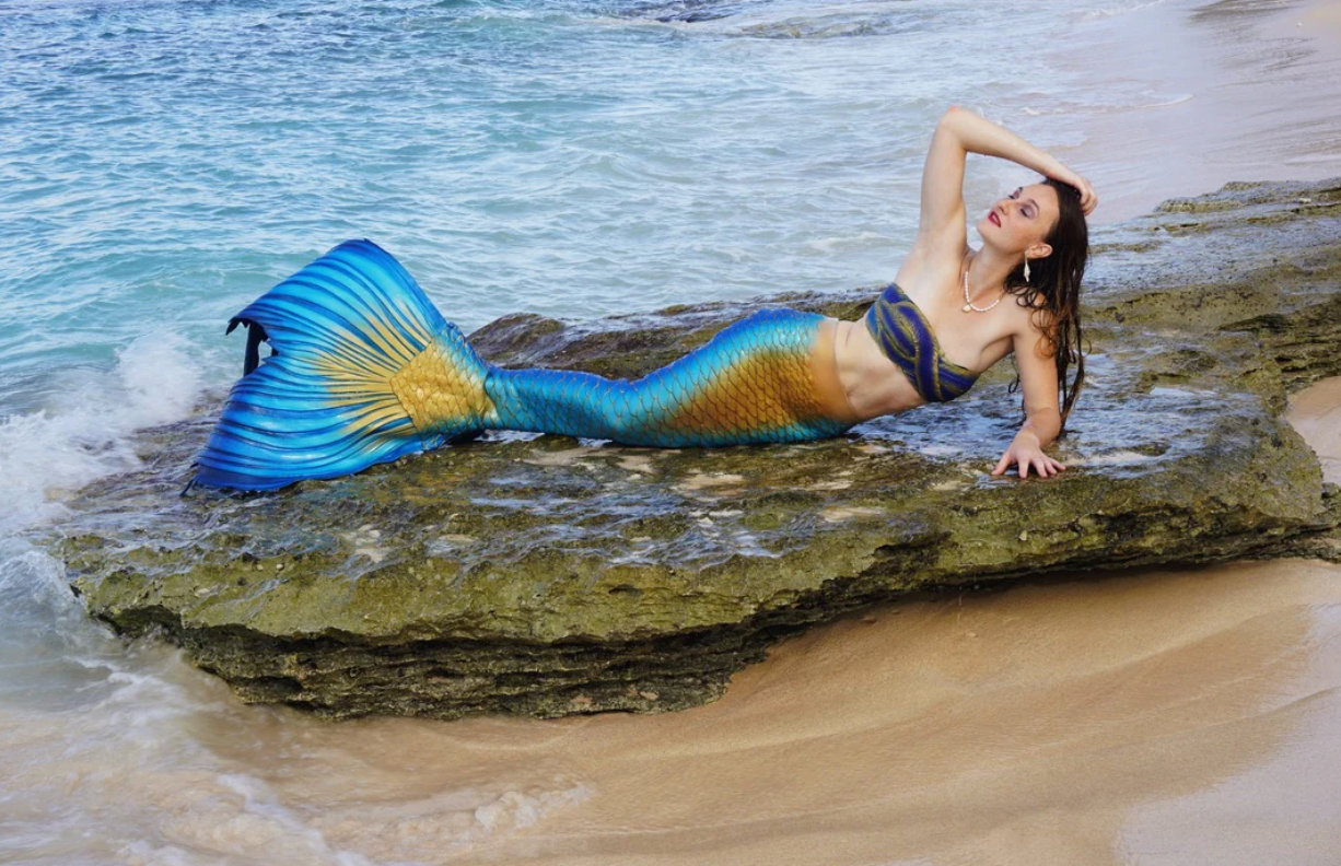 Blue and gold iridescent silicone mermaid tail on beach